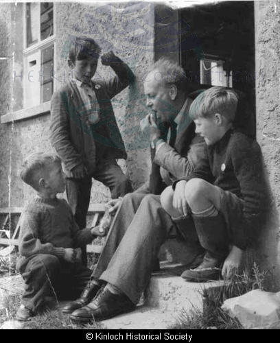 Godfrey Winn and young friends outside a shop in Laxay